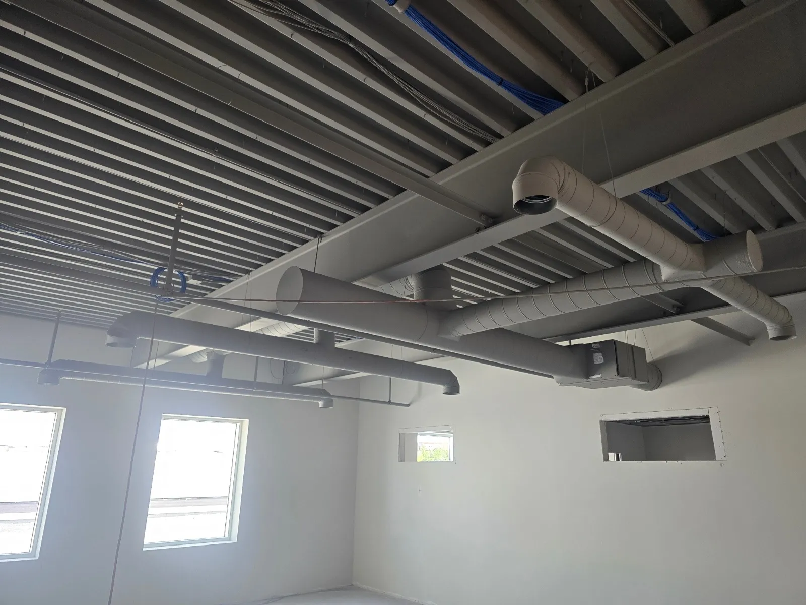 Painted spiral round ductwork running through an open-ceiling commercial fit-up in Halifax